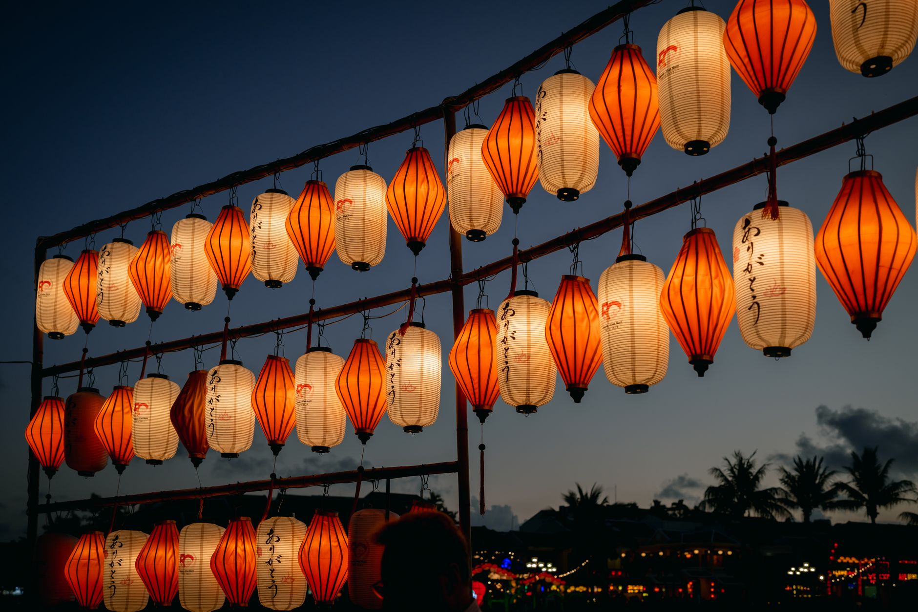 Rows of glowing lanterns strung above the night bazaar